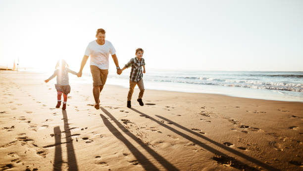 istock happiness father running on the beach with kids 1160905434