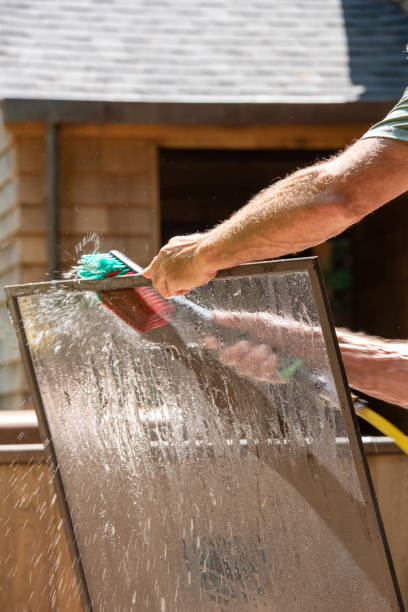 istock Man washing window screens with brush and water 1160905677