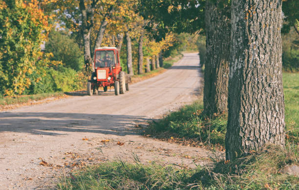 istock Tractor driving on a rural road 1160906928