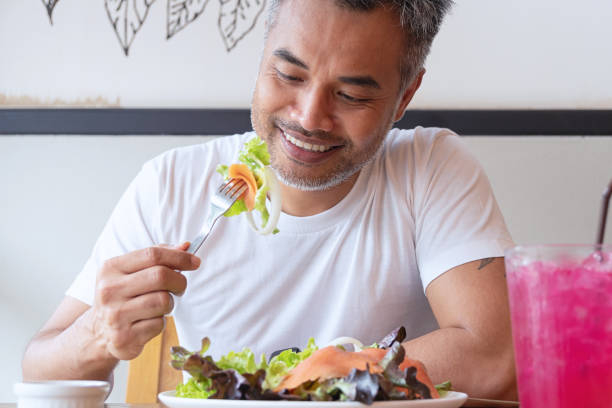 Young happy man enjoying in a healthy meal