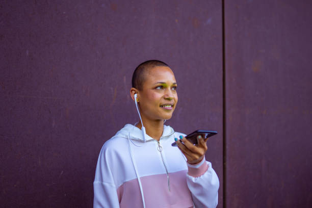 Cool young woman leaving a voice message on her smart phone stock photo