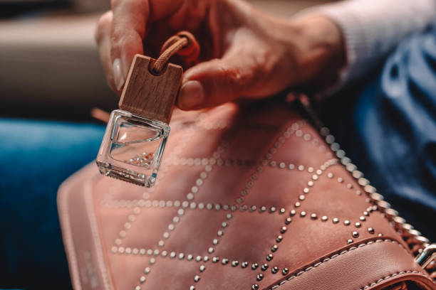 istock Small glass bottle with car perfume in female hand. 1160912626