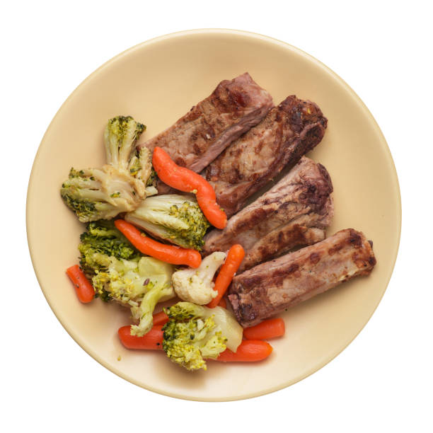 istock grilled pork ribs with broccoli cabbage, carrots and garlic on a plate. fried   ribs with vegetables on a white background. hearty rustic food top view 1160912822