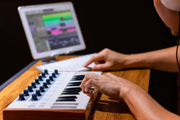 male composer arranging music on midi keyboard and tablet computer in home studio - human finger sound mixer music producer imagens e fotografias de stock