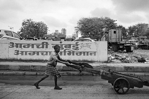 A man pushing the cart on the streets on Mumbai. Manual labors are often seen on the streets doing these routine jobs to make their ends meet.