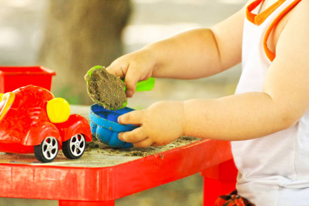 the child plays in the warm season. - sandbox child human hand sand imagens e fotografias de stock