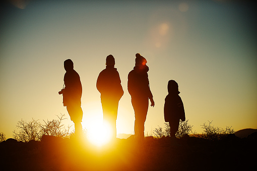 Silhouette women with hats and girl at sunrise Namib Desert Namibia Africa
