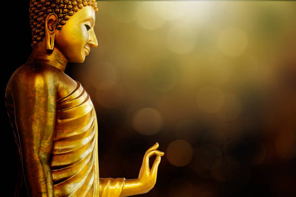istock Ancient golden Buddha statue standing on blurred golden bokeh background 1160924097