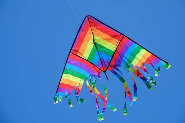 istock Kite flying in blue sky summer background,  white tail. 1160925381