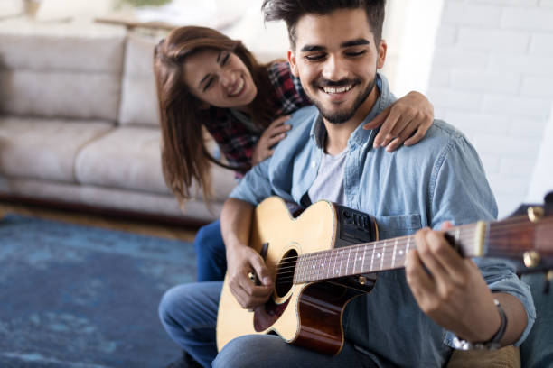 istock Young handsome man playing guitar for his girlfriend 1160926325