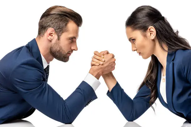 Photo of businessman and businesswoman in formal wear arm wrestling isolated on white