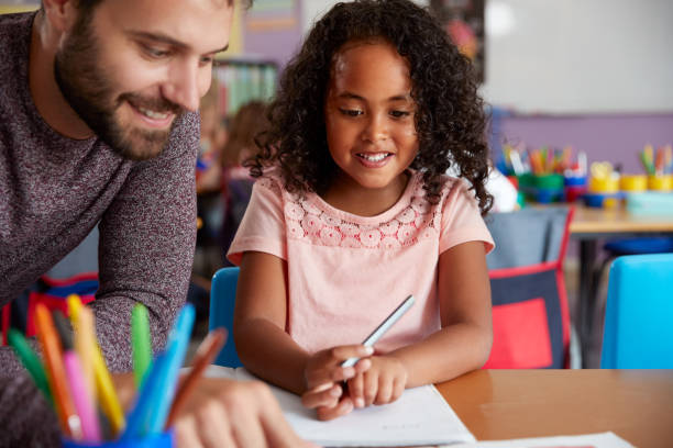 istock Elementary School Teacher Giving Female Pupil One To One Support In Classroom 1160927460