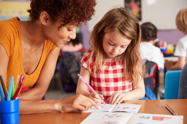 istock Elementary School Teacher Giving Female Pupil One To One Support In Classroom 1160927685