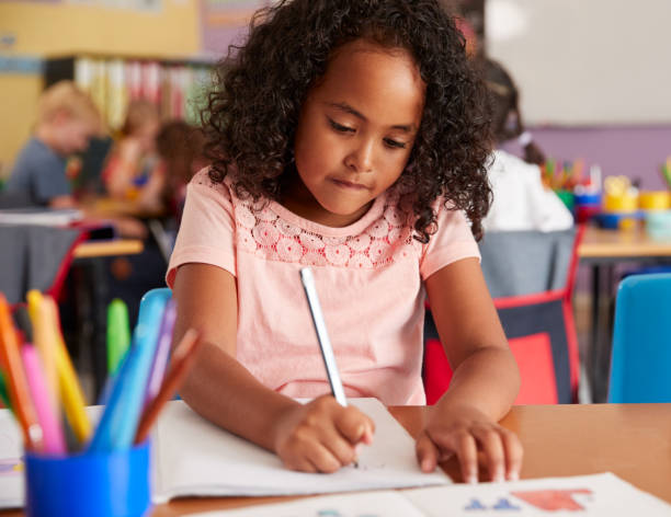 istock Concentrating Female Elementary School Pupils Working At Desk 1160927952