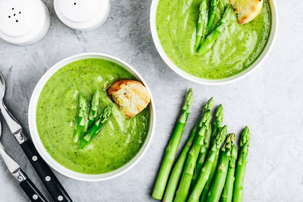 istock Asparagus cream soup with croutons on gray stone background. 1160928579