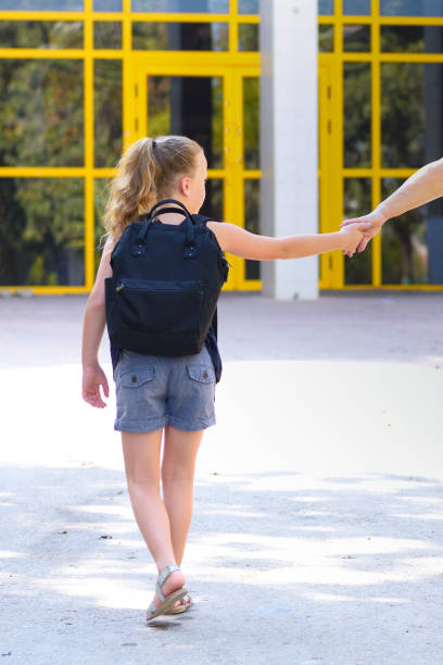 istock Pupil kid holding hands with parent going to school. 1160930436