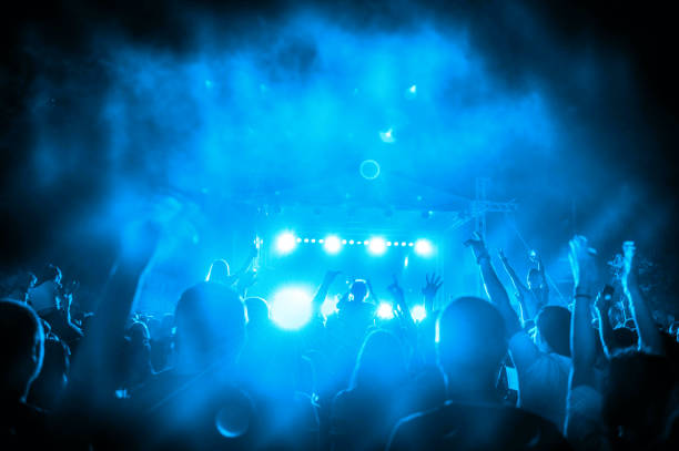 istock Concert crowd in front of bright stage lights 1160932354