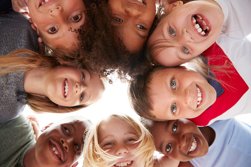 Grupo de niños multiculturales con amigos mirando hacia abajo en la cámara photo