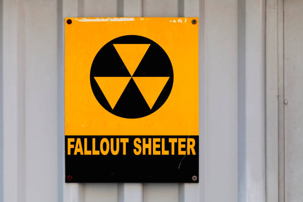 Fallout shelter sign Black nuclear symbol drawn on a yellow placard with written in "Fallout shelter". nuclear fallout stock pictures, royalty-free photos & images