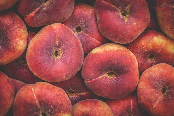 doughnut peach or flat saturn peach closeup background with full frame captured by peaches. toned - nectarine peach red market imagens e fotografias de stock