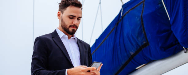 istock Man working on smartphone on yacht 1160938637