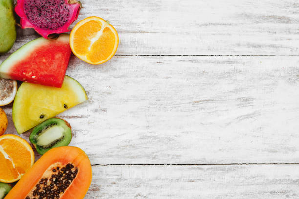 istock Tropical fruits lie on a wooden white surface. 1160939324