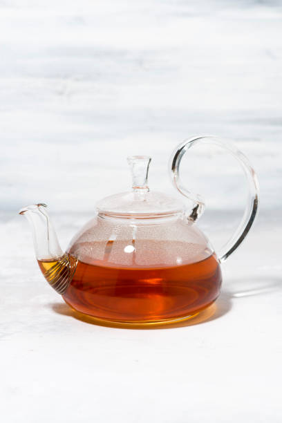 istock tea in a glass teapot on a white background, vertical 1160939356