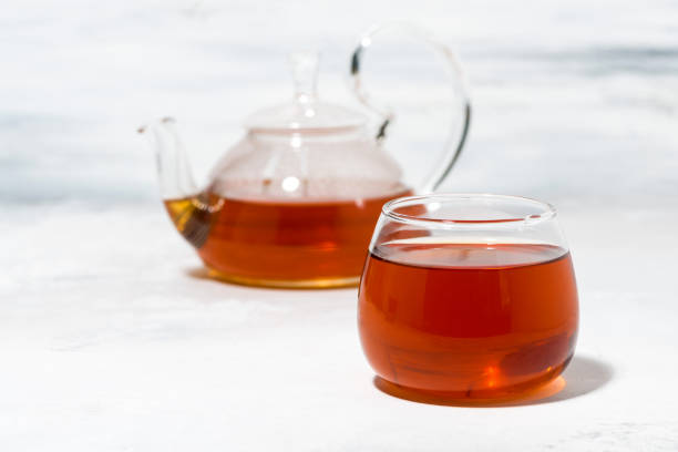 istock glass cup of tea and teapot on white table 1160939507