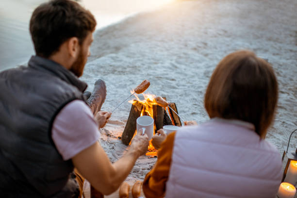 istock Couple cooking sausages on the beach 1160941543