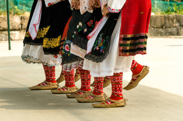 chicas bailando danza folclórica. la gente con trajes tradicionales bailan bailes folclóricos búlgaros. primer plano de las piernas femeninas con zapatos tradicionales, calcetines y disfraces para bailes folclóricos. - balcanes fotografías e imágenes de stock