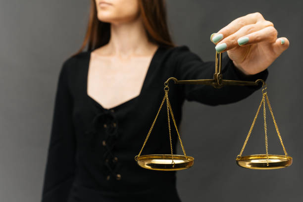 istock Serious woman holding the justice scale on dark background 1160943453