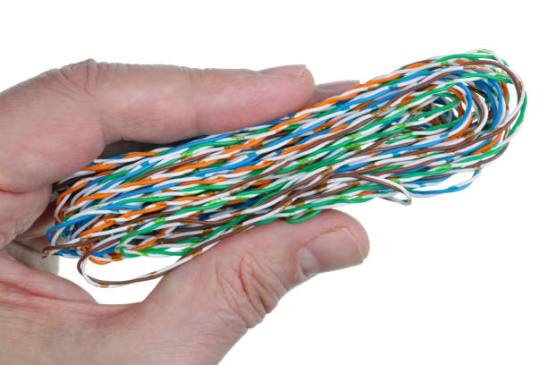 istock Elderly male technician holds in his hand a coil of computer twisted wire. Isolated 1160943946