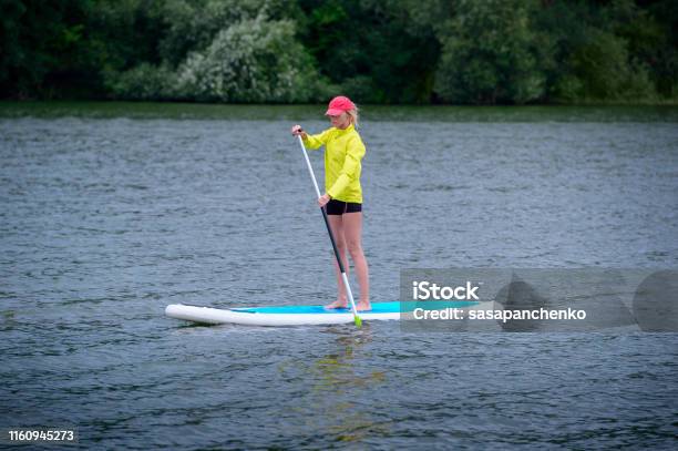 A Woman Is Floating On A Sup Board Along A Large River Stand On The Paddle Boarding Amazing Outdoor Activities Stock Photo - Download Image Now