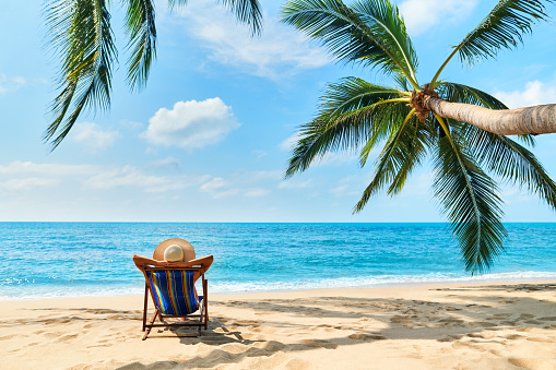 Vista trasera de joven hermosa mujer tomar el sol y relajarse en la playa tropical con espacio de copia photo