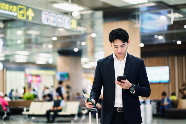 istock Businessman using phone while waiting at airport 1160947508