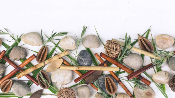 istock Horizontal spa oriental composition. Dry bamboo, sea pebbles, grass leaves on a wooden white background. 1160947549