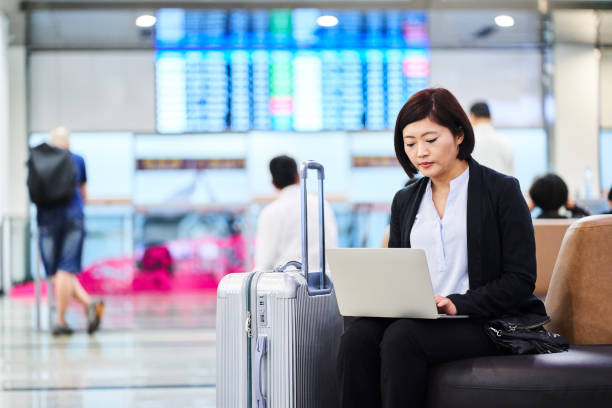 istock Confident businesswoman using laptop in airport 1160947672