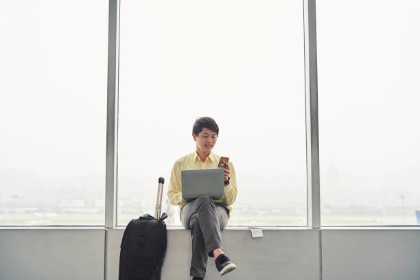 istock Male entrepreneur using cellphone on window sill 1160948112