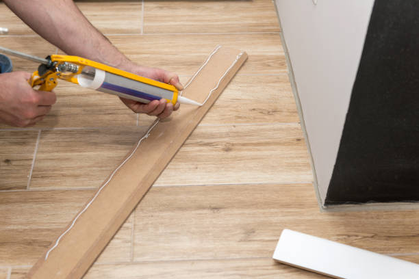 istock Installing white skirting board with caulking gun 1160956151