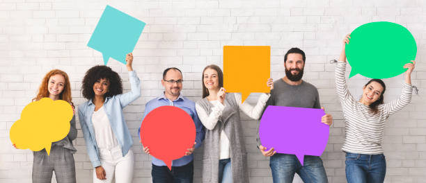istock Group of diverse people holding colorful speech bubbles 1160960554