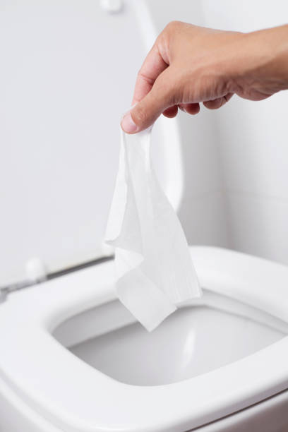istock man throwing a wet wipe to the toilet 1160962334