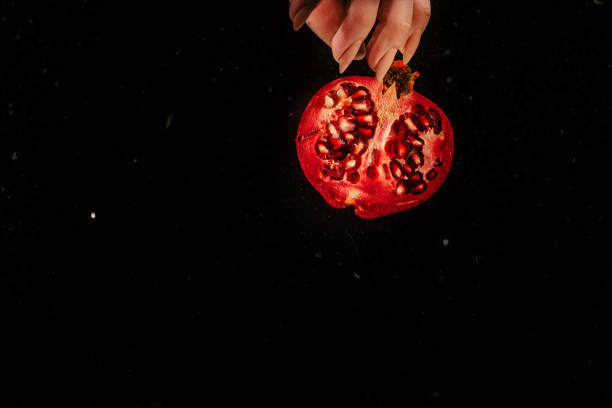 istock Half of red pomegranate splashes water in aquarium 1160963257
