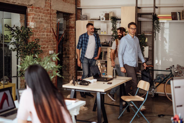 istock Colleagues talking and entering office together 1160963741