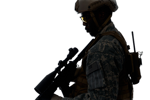 Silhouette of professional American soldier with modern weapons machine. Male serve in army, wearing helmet, armour and keeping position. Concept of war.