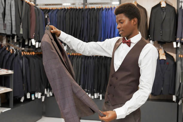 istock Man holding grey jacket on hanger, looking, choosing . 1160964752