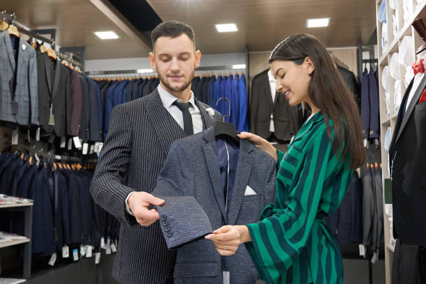 istock Client and shop consultant looking and trying on jacket. 1160964762
