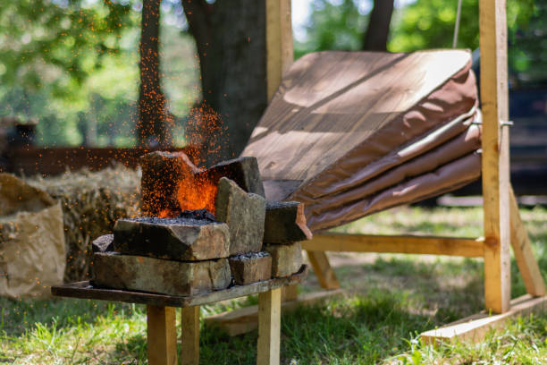 istock Medieval bellows make the fire of coals and sparks fly from outdoor blacksmith 1160965536