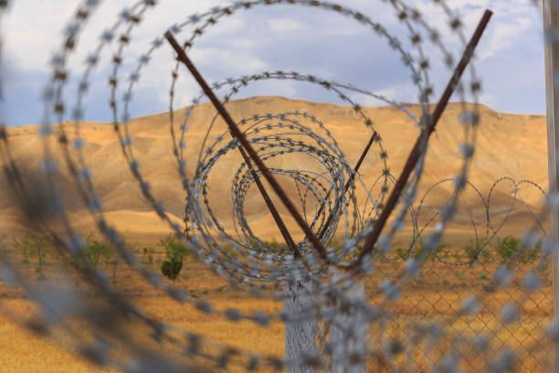 istock Barbed wire drawn in circles against a background of mountains 1160966581