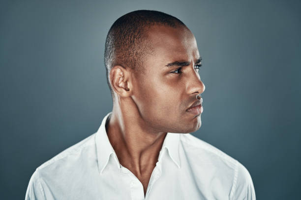 istock Confident look. Handsome young African man in shirt looking away while standing against grey background 1160970329