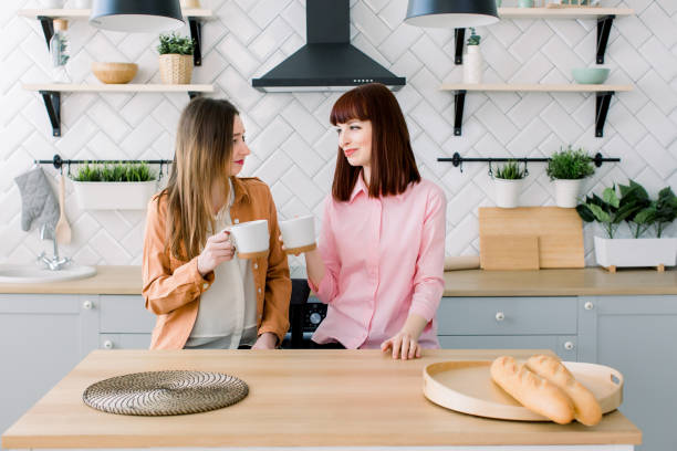 istock Two Female Caucasian Friends sipping coffee in kitchen 1160970843